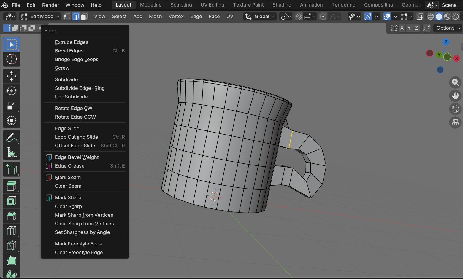 Coffee mug in Edit Mode with an edge at the handle-to-body junction selected in orange and the Edge menu (Ctrl+E) open, showing the Mark Sharp option. Marking the edge sharp gives explicit control over shading at the connection.